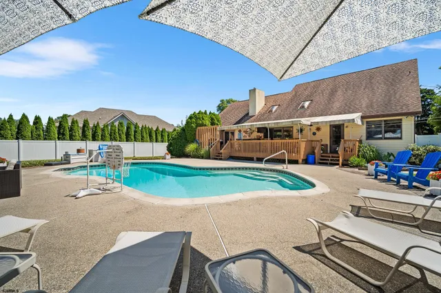 a view of a patio with couches and table under an umbrella