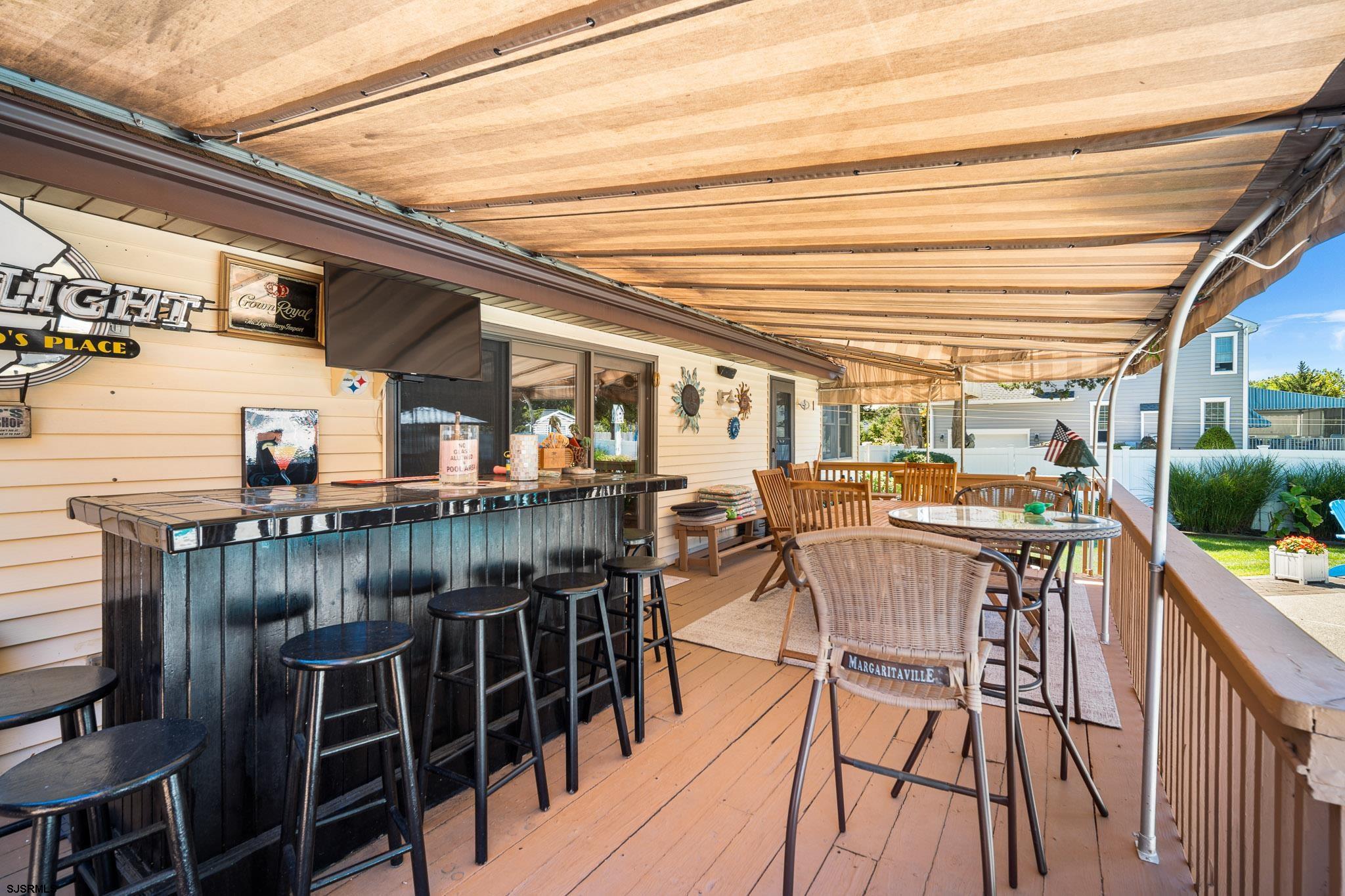 202 North Shore Road Marmora, NJ 08223 - Photo 8 of 31 a view of a patio with table and chairs with wooden floor and fence