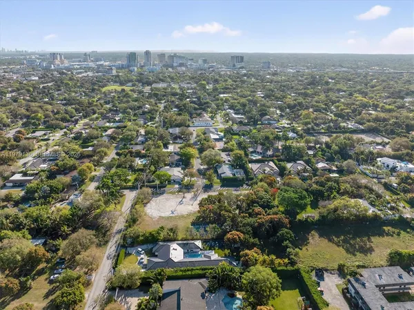 an aerial view of residential houses with outdoor space and trees