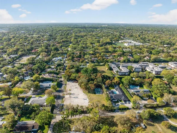 an aerial view of residential houses with outdoor space and trees