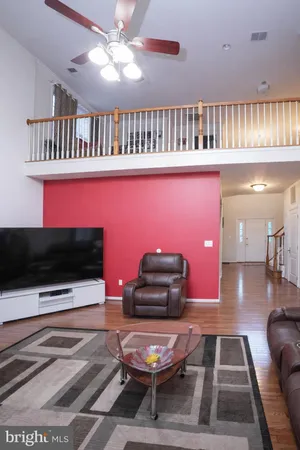 a living room with furniture a flat screen tv and a floor to ceiling window