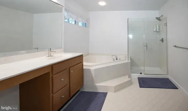a bathroom with a tub sink and mirror