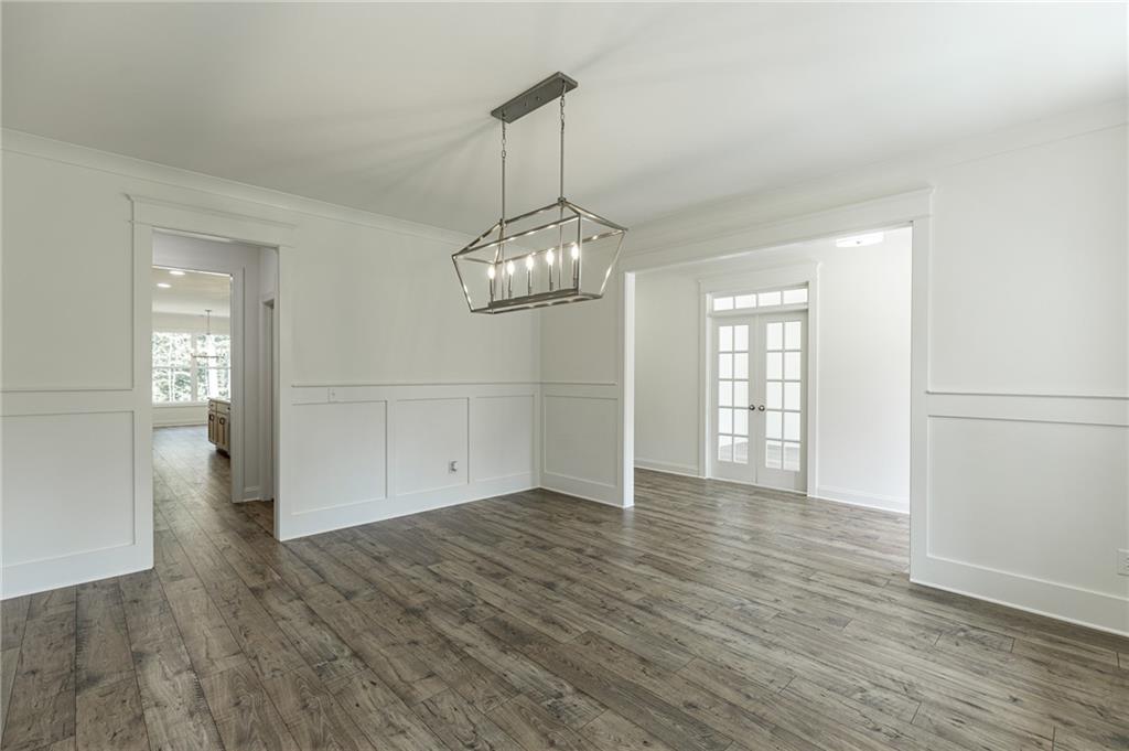 1210 Austin Road Winder, GA 30680 - Photo 11 of 56 an empty room with wooden floor cabinet and windows