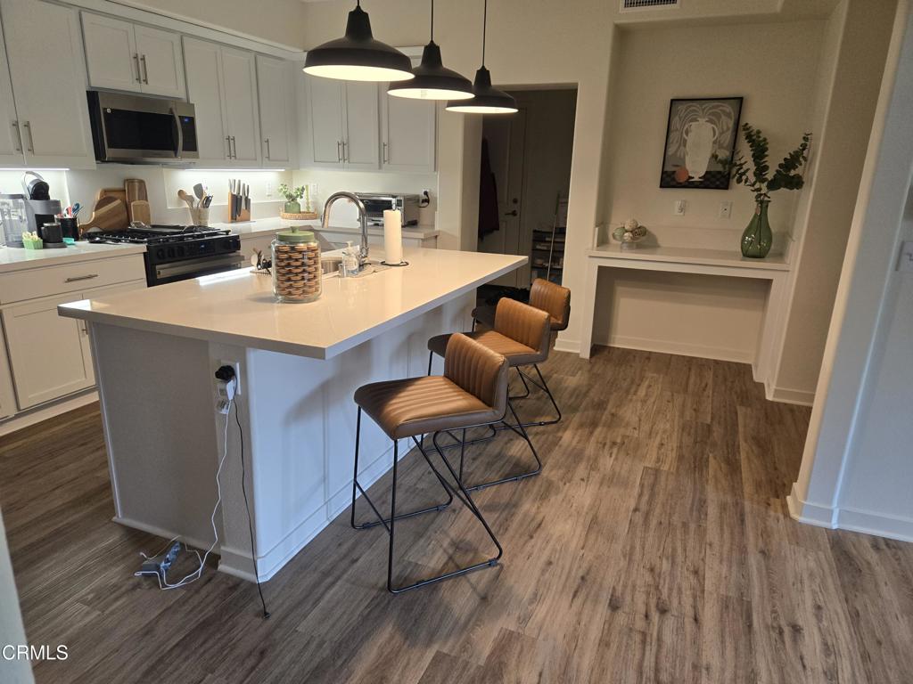 307 North F Street, Unit 102 Oxnard, CA 93030 - Photo 5 of 12 a kitchen with a sink a microwave a stove and refrigerator
