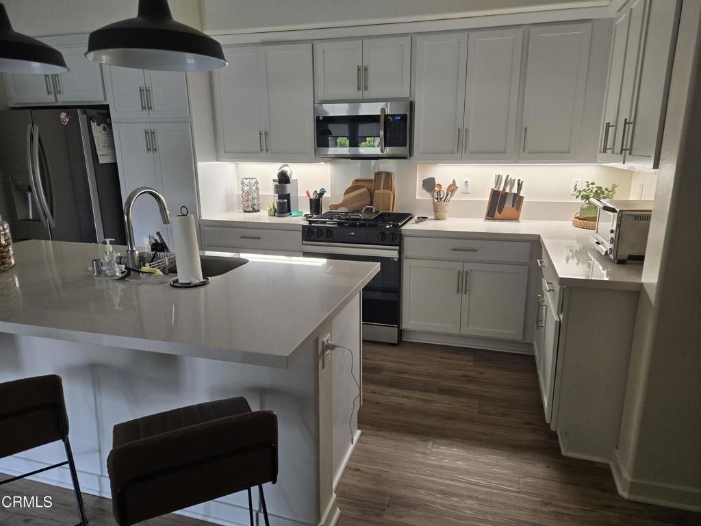 307 North F Street, Unit 102 Oxnard, CA 93030 - Photo 7 of 12 a kitchen with a sink cabinets and stainless steel appliances