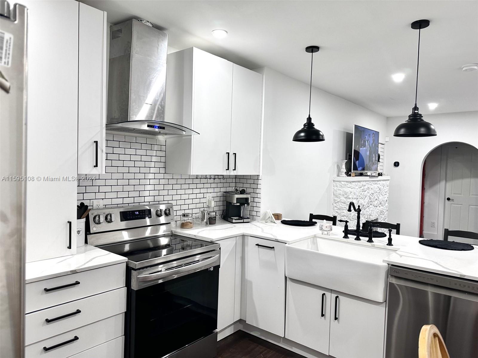923 Southwest 13th Court Miami, FL 33135 - Photo 14 of 58 a kitchen with stainless steel appliances granite countertop a sink a stove and a wooden floors
