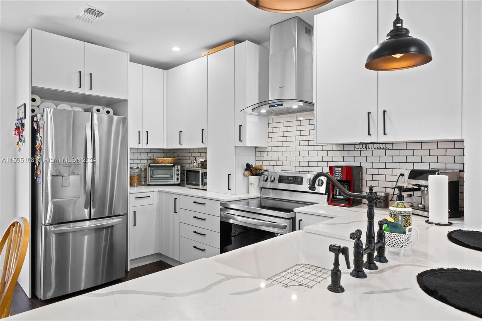 923 Southwest 13th Court Miami, FL 33135 - Photo 17 of 58 a kitchen with stainless steel appliances kitchen island granite countertop a refrigerator a stove a sink dishwasher with a dining table and chairs