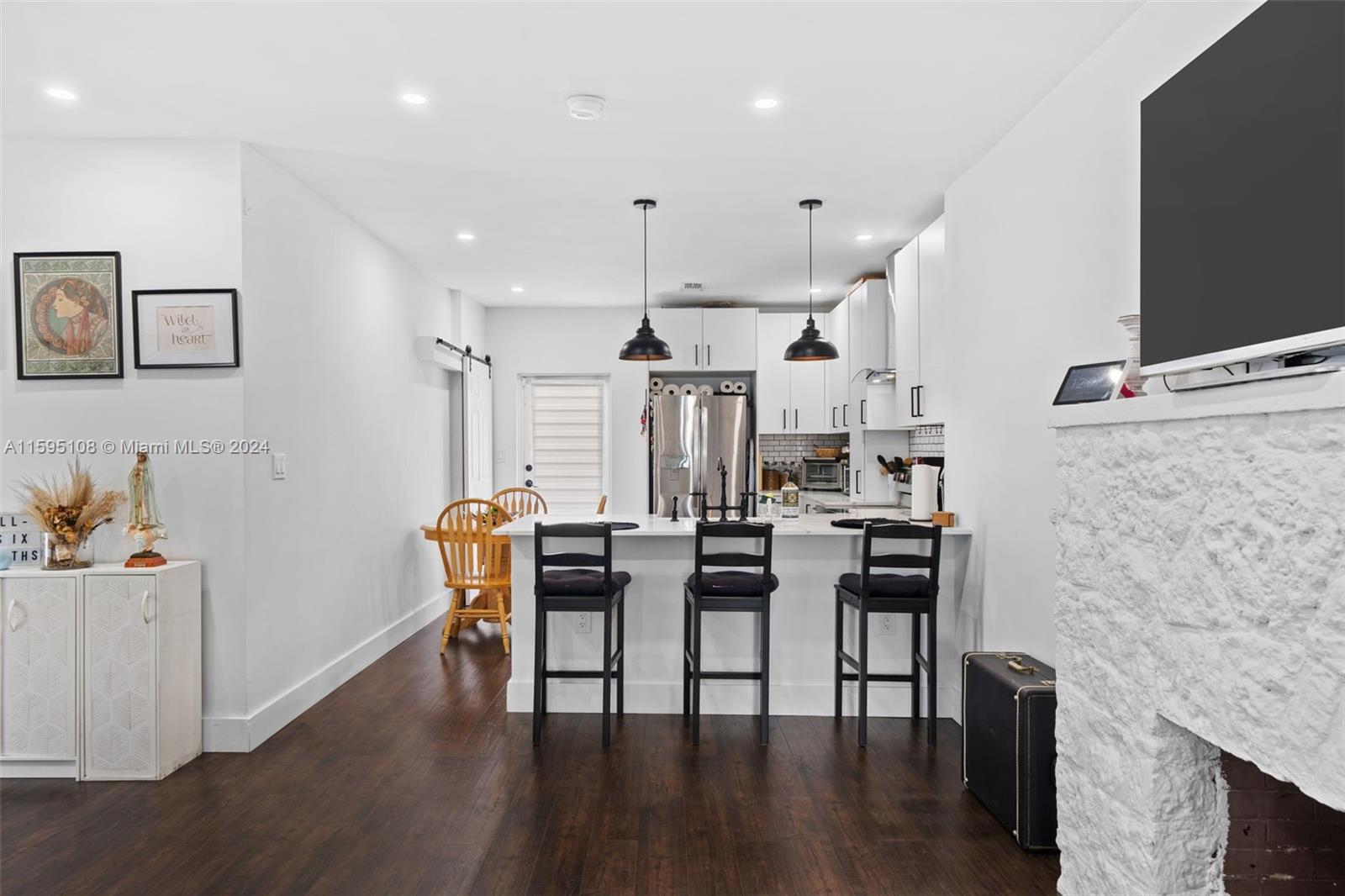 923 Southwest 13th Court Miami, FL 33135 - Photo 20 of 58 a dining room with stainless steel appliances kitchen island granite countertop a table chairs and a refrigerator