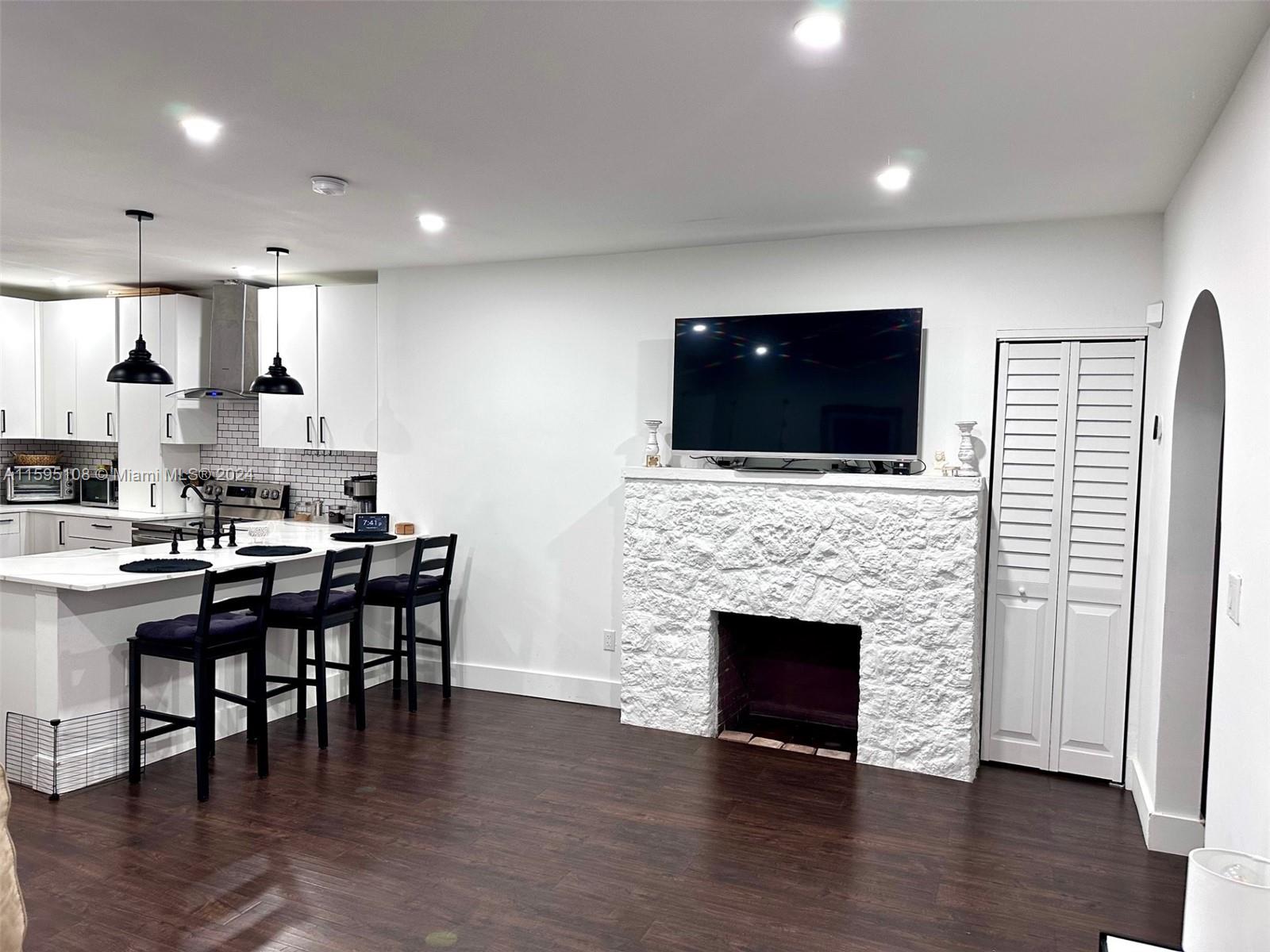 923 Southwest 13th Court Miami, FL 33135 - Photo 21 of 58 a living room with stainless steel appliances furniture a fireplace a flat screen tv and view living room