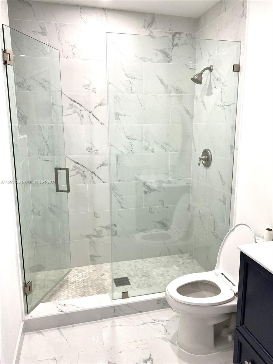 923 Southwest 13th Court Miami, FL 33135 - Photo 37 of 58 a bathroom with a granite countertop toilet sink and shower