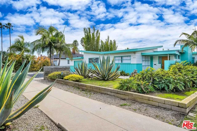 a view of a house with backyard and a tree