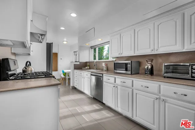 a kitchen with stainless steel appliances granite countertop a stove sink and cabinets