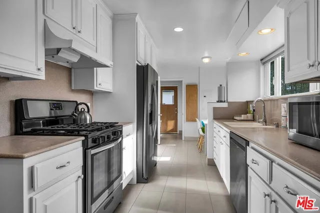a kitchen with stainless steel appliances granite countertop a stove sink and cabinets