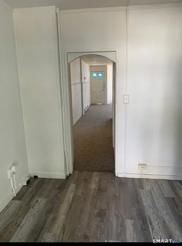 an empty room with wooden floor and mirror