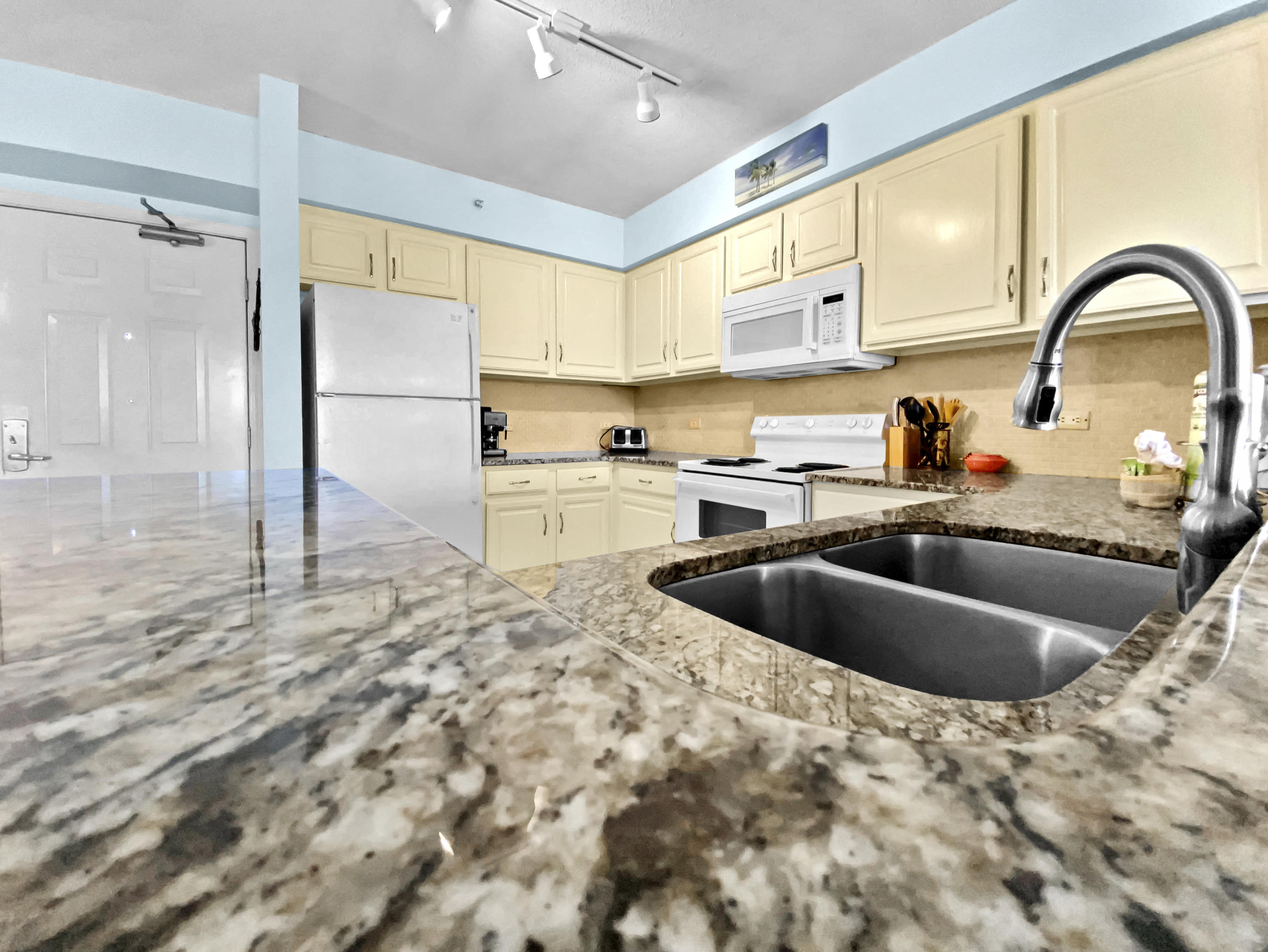 970 Highway 98, Unit 206 Destin, FL 32541 - Photo 1 of 25 a kitchen with a stove a sink and a refrigerator