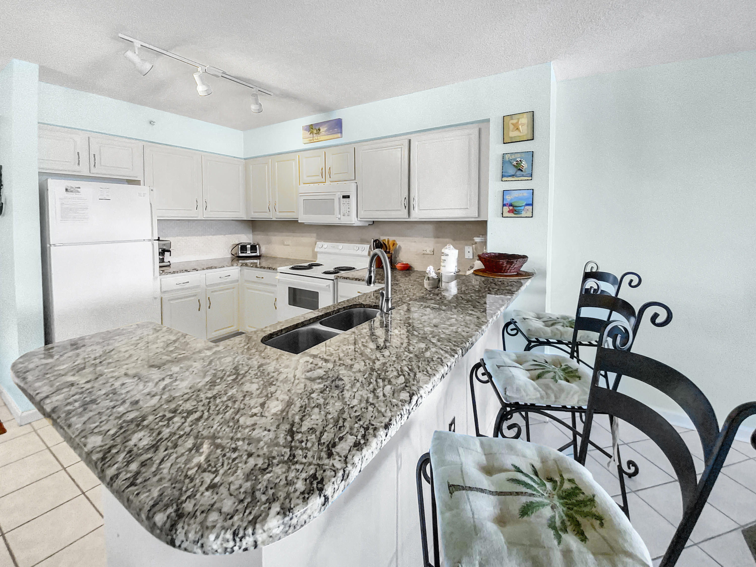 970 Highway 98, Unit 206 Destin, FL 32541 - Photo 21 of 25 a kitchen with stainless steel appliances granite countertop a sink a stove and a refrigerator