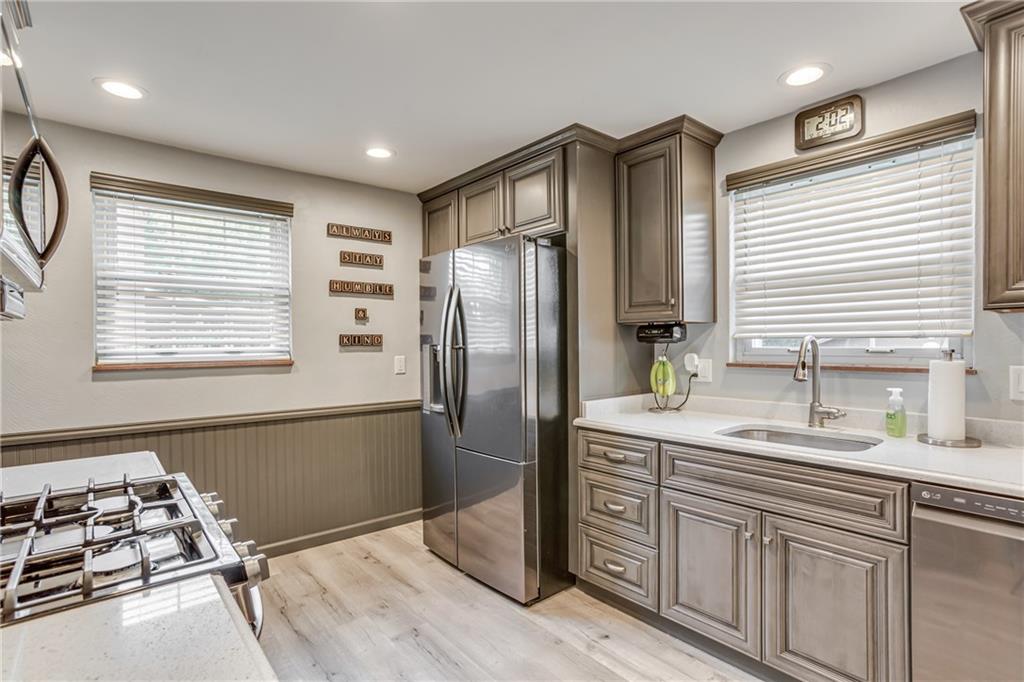 Kitchen with Trendy Gray Cabinets, Quartz Counter Tops, Stainless Steel Appliances & Luxury Vinyl Flooring