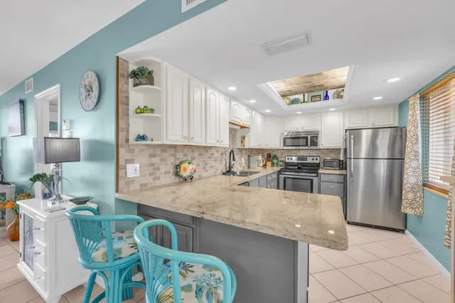 a kitchen with stainless steel appliances granite countertop a refrigerator and a stove top oven