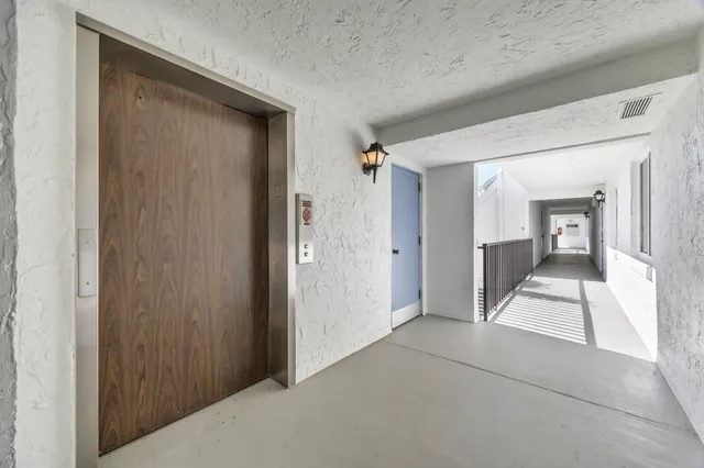 a view of a hallway with wooden shelves
