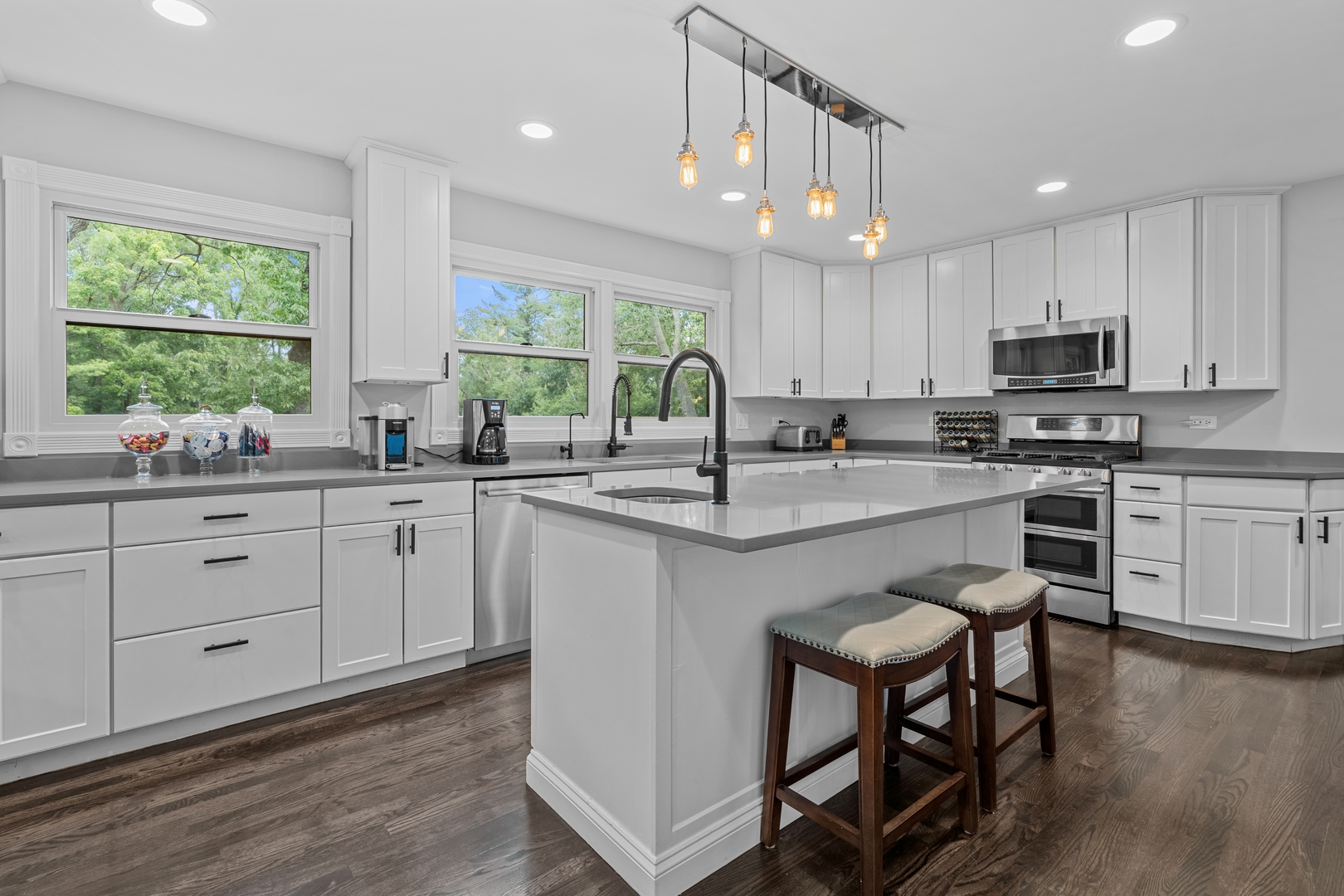 906 Bridle Lane Cary, IL 60013 - Photo 18 of 61 a kitchen with stainless steel appliances granite countertop white cabinets a sink a stove a dining table and chairs