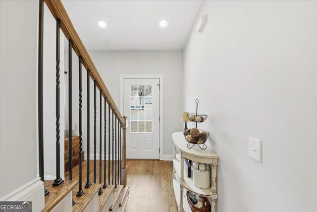 a view of a hallway with wooden floor and staircase