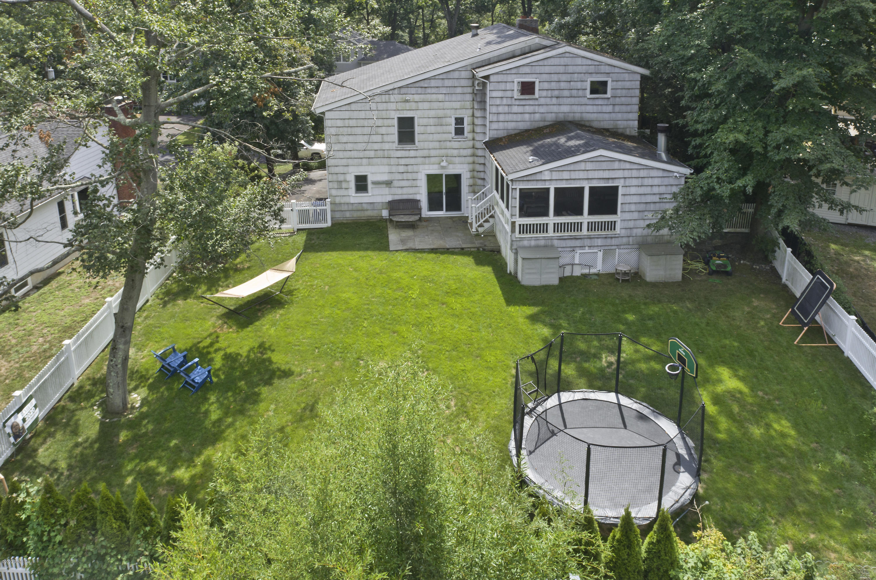 19 Gregory Road Cos Cob, CT 06807 - Photo 2 of 22 a aerial view of a house with table and chairs under an umbrella