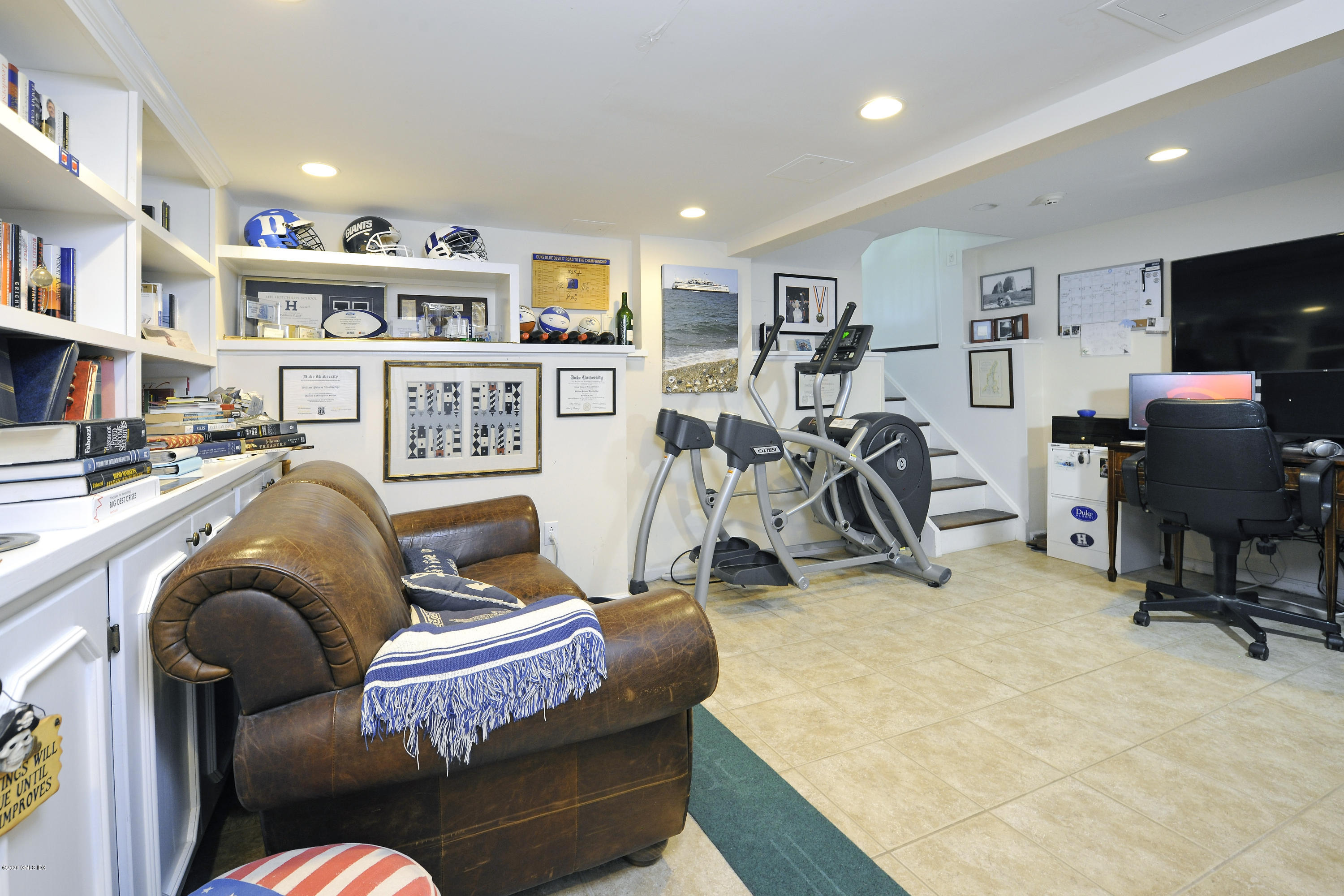 19 Gregory Road Cos Cob, CT 06807 - Photo 22 of 22 a living room with furniture a flat screen tv and gym equipment