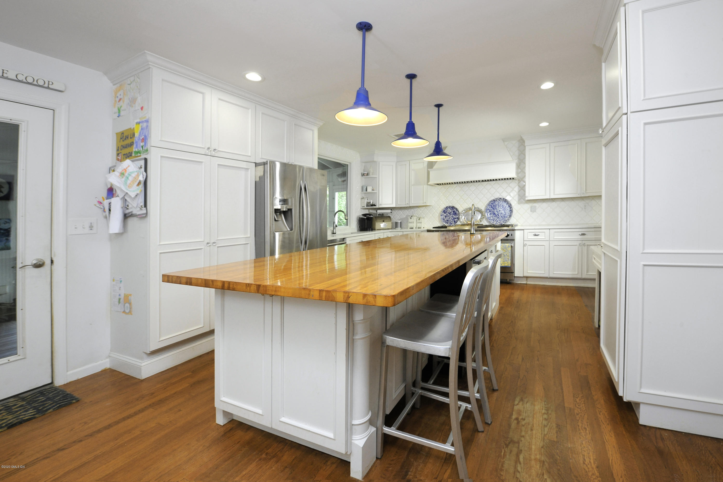 19 Gregory Road Cos Cob, CT 06807 - Photo 9 of 22 a kitchen with stainless steel appliances a dining table chairs stove refrigerator and microwave