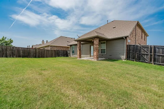 a view of a house with a yard and fence