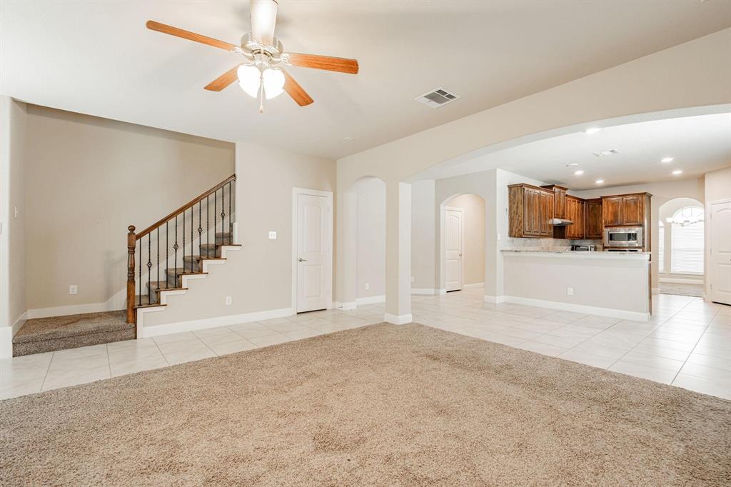 529 England Street Fate, TX 75189 - Photo 6 of 11 a view of a livingroom with a ceiling fan and kitchen view