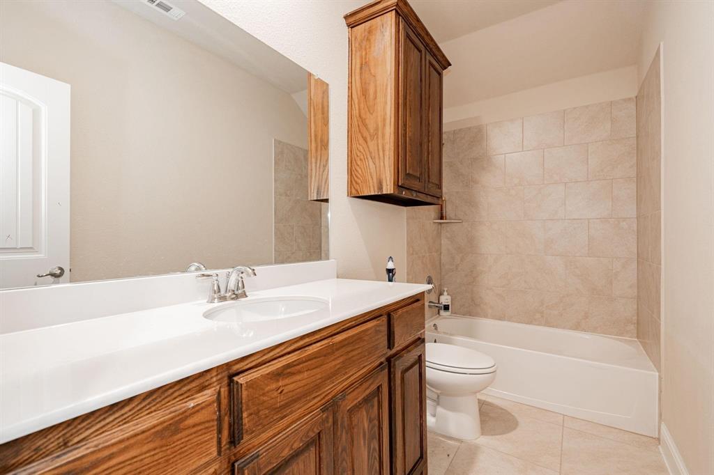 529 England Street Fate, TX 75189 - Photo 8 of 11 a bathroom with a sink a toilet and a mirror
