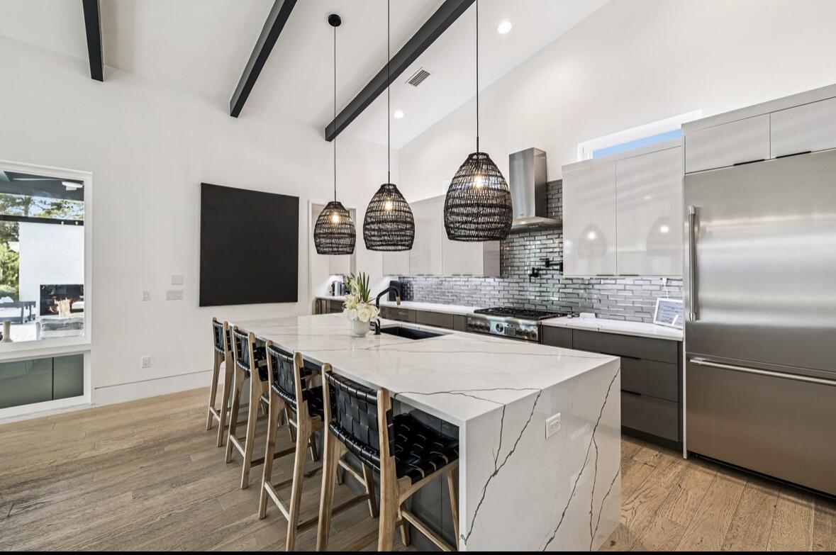 114 Surfside Drive Santa Rosa Beach, FL 32459 - Photo 6 of 45 a kitchen with stainless steel appliances a sink a stove a refrigerator and island