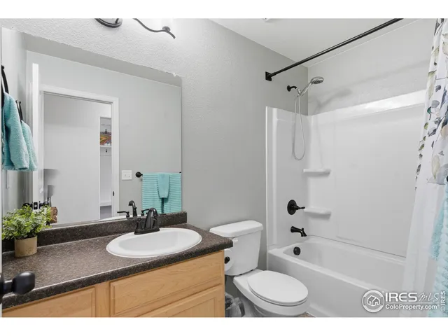 a bathroom with a granite countertop sink toilet a mirror and shower
