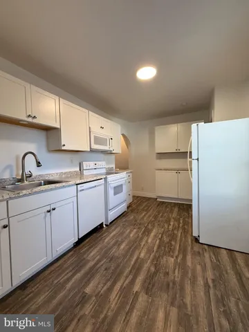 a kitchen with white cabinets and white appliances
