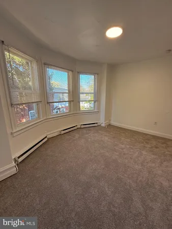 an empty room with windows and ceiling fan
