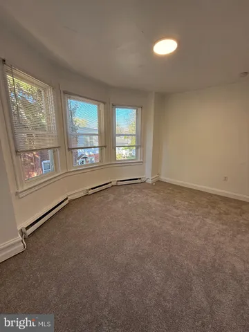 an empty room with windows and ceiling fan