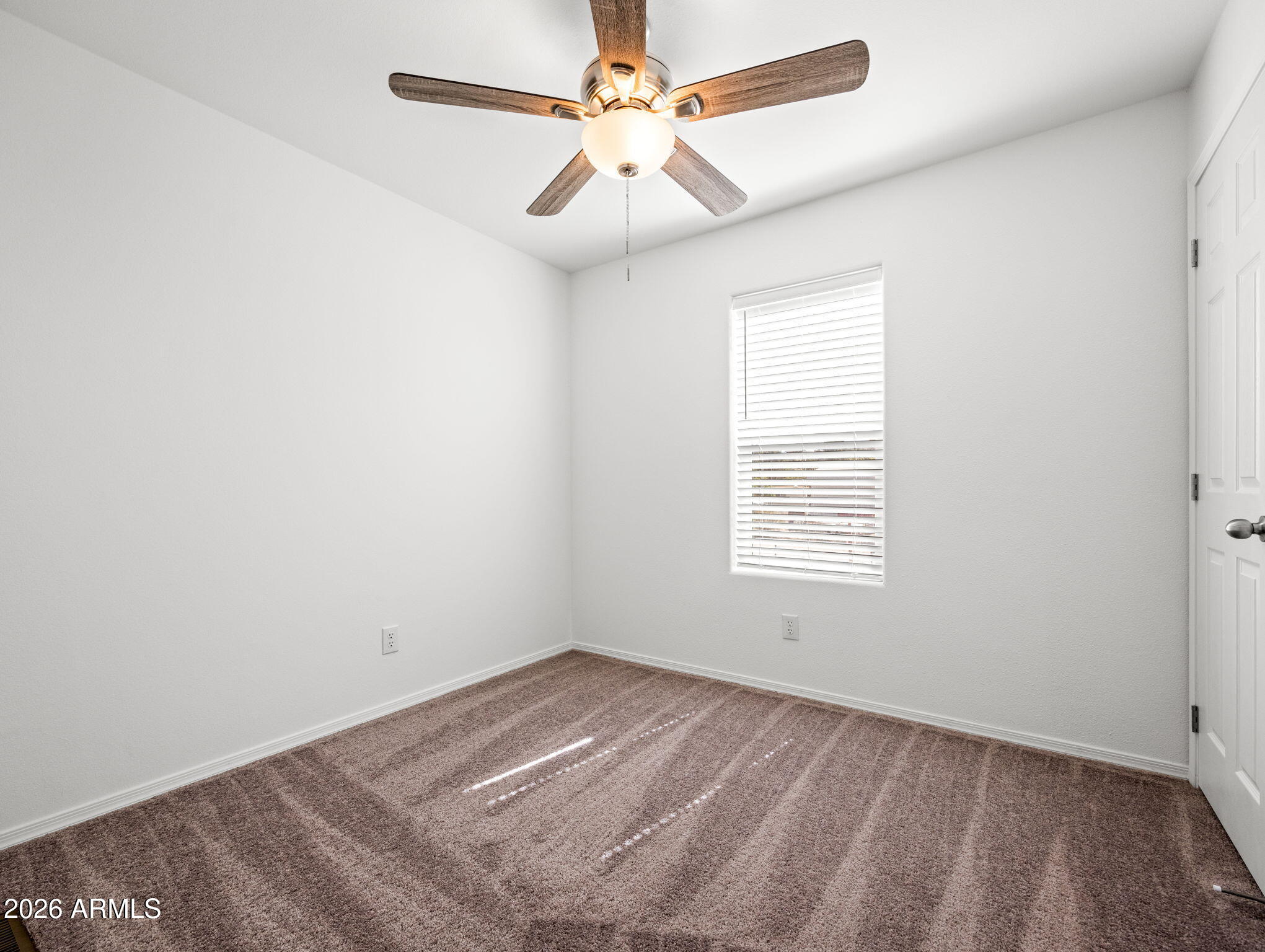 18296 Frontier Road Peeples Valley, AZ 86332 - Photo 17 of 44 an empty room with a window and a fan