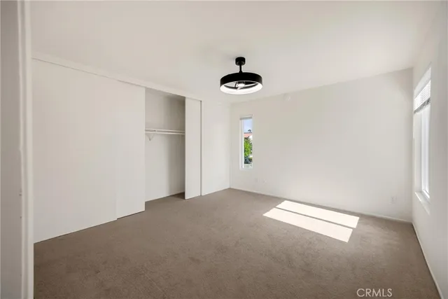 an empty room with a window and a ceiling fan