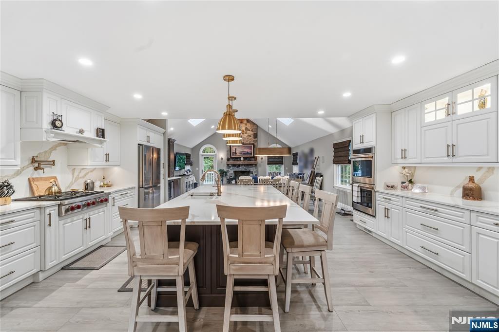854 Cambridge Road River Vale, NJ 07675 - Photo 10 of 50 a kitchen with stainless steel appliances kitchen island granite countertop a dining table chairs and white cabinets