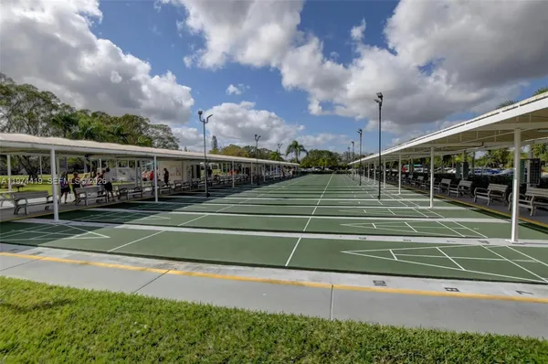 a view of a tennis ground and large trees