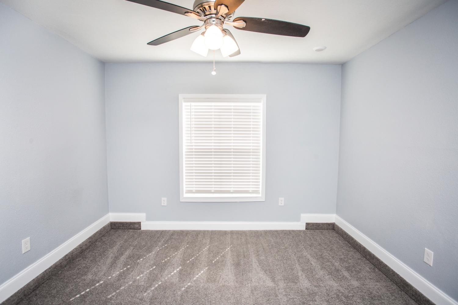 4804 44th Street Lubbock, TX 79414 - Photo 14 of 32 an empty room with a window and a fan