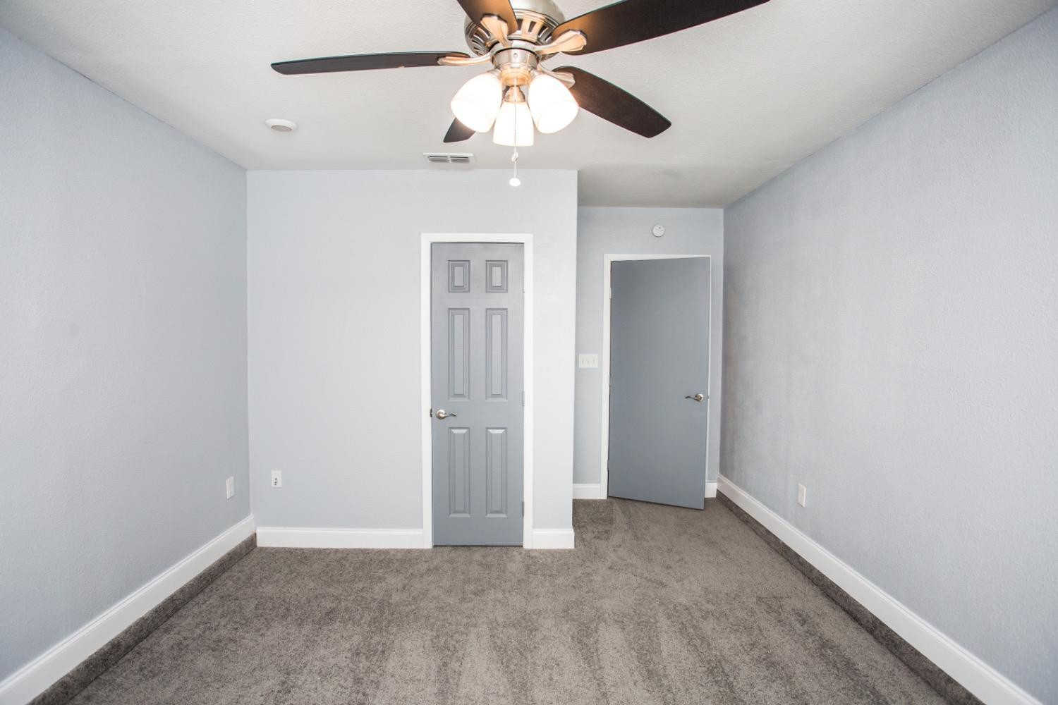 4804 44th Street Lubbock, TX 79414 - Photo 15 of 32 an empty room with closet and a chandelier fan