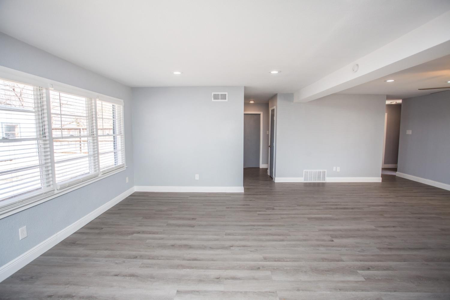 4804 44th Street Lubbock, TX 79414 - Photo 16 of 32 a view of an empty room with wooden floor and a window