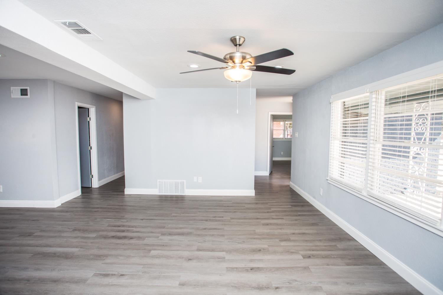 4804 44th Street Lubbock, TX 79414 - Photo 18 of 32 a view of an empty room with wooden floor and a window