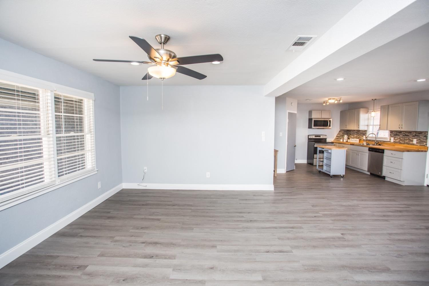 4804 44th Street Lubbock, TX 79414 - Photo 19 of 32 a view of a kitchen with a stove cabinets a ceiling fan and wooden floor