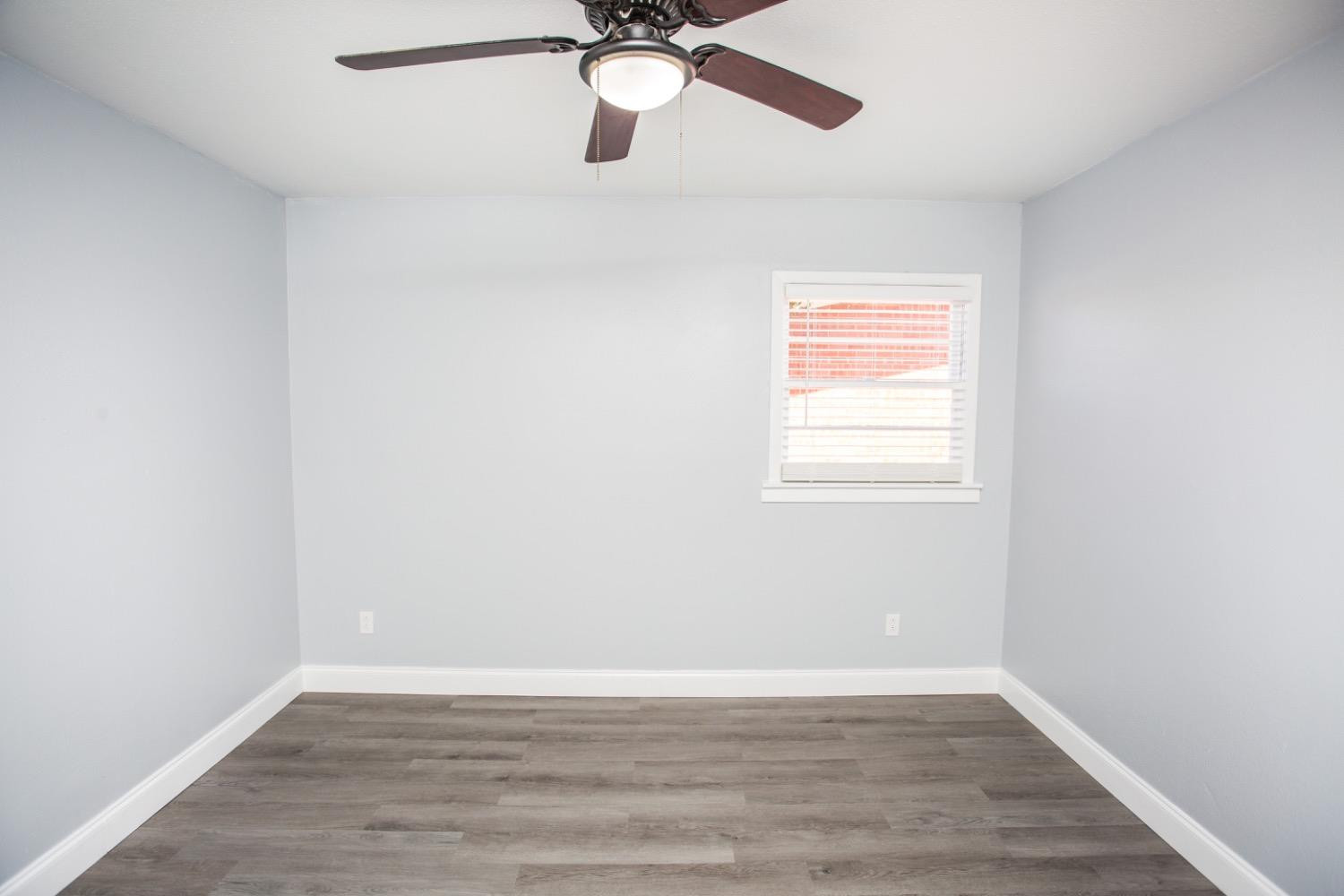 4804 44th Street Lubbock, TX 79414 - Photo 29 of 32 a view of an empty room with wooden floor and a window