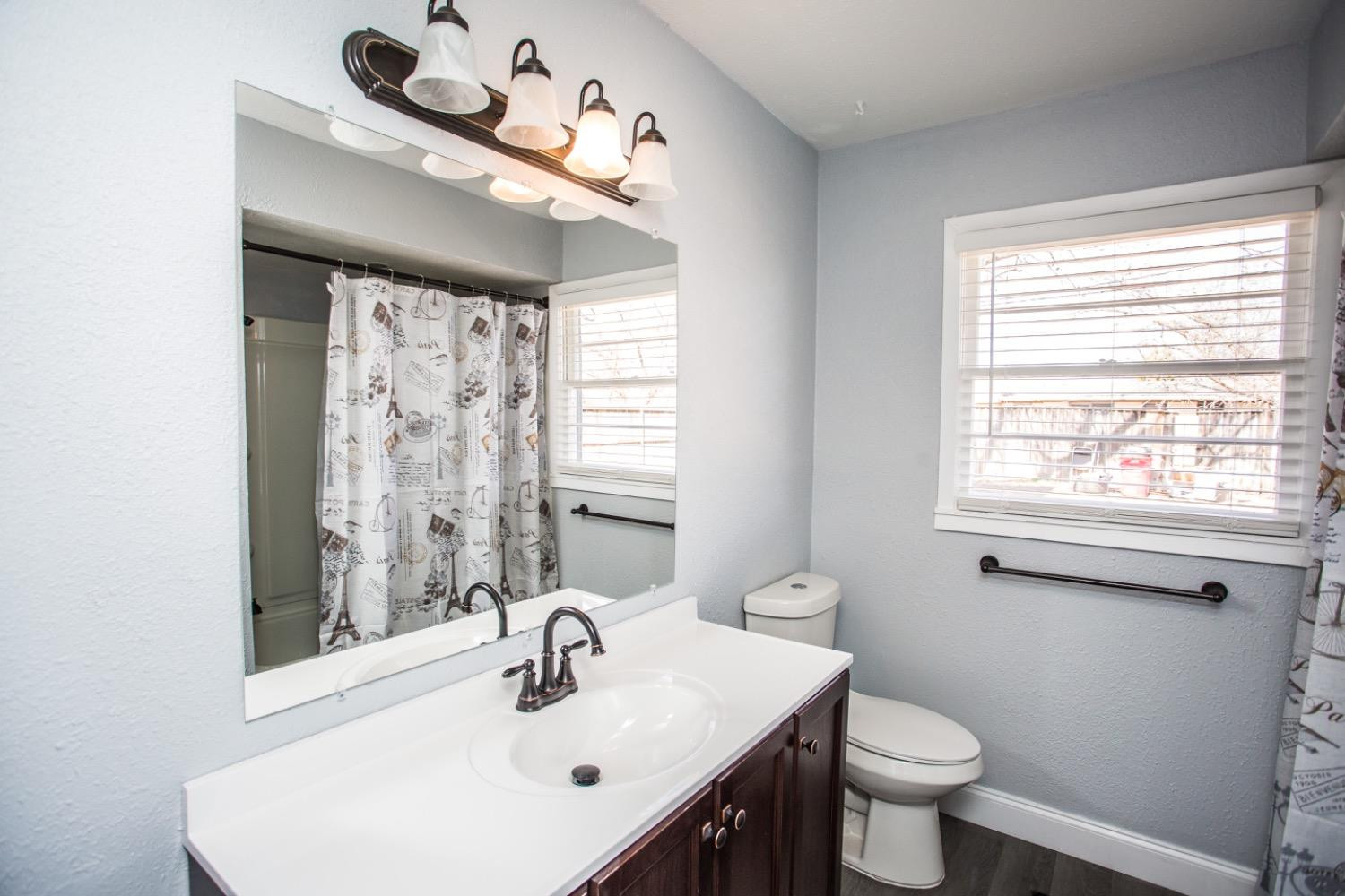 4804 44th Street Lubbock, TX 79414 - Photo 30 of 32 a bathroom with a sink toilet and a mirror