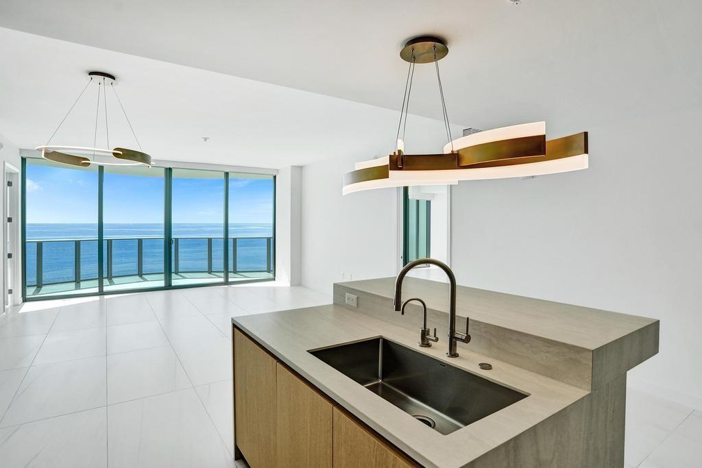 900 North Ocean Boulevard, Unit 1405 Pompano Beach, FL 33062 - Photo 12 of 67 a kitchen with a sink and a refrigerator