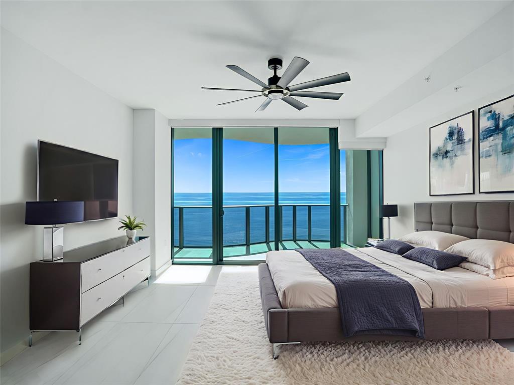 900 North Ocean Boulevard, Unit 1405 Pompano Beach, FL 33062 - Photo 19 of 67 a bedroom with a large bed and a flat screen tv