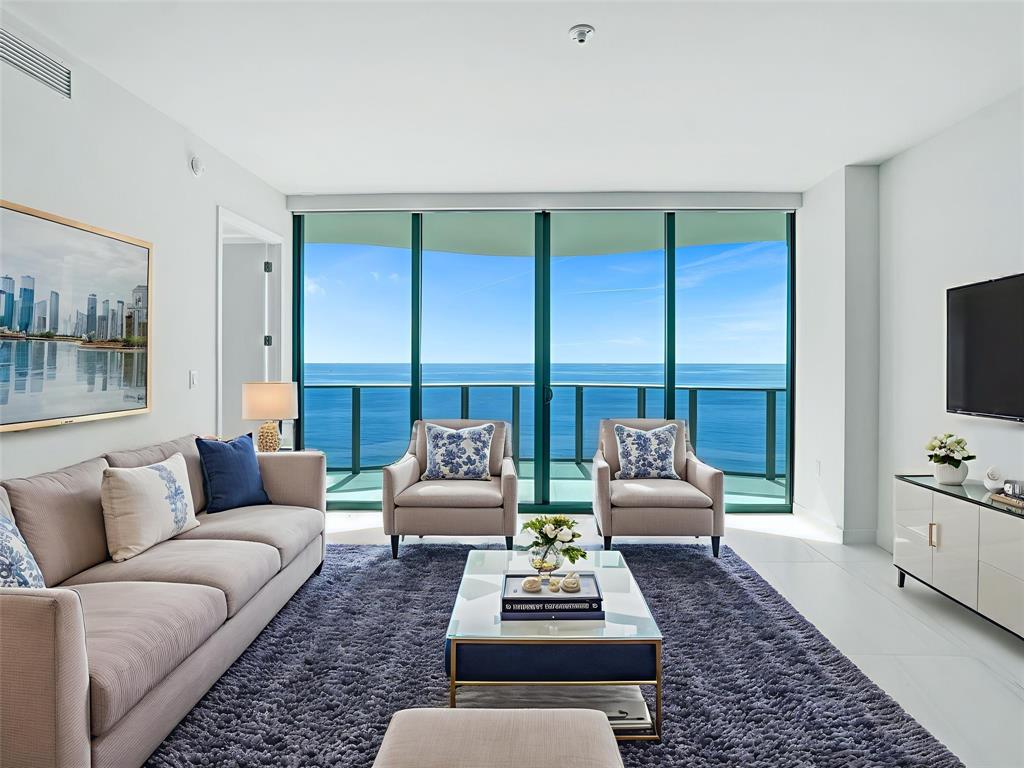 900 North Ocean Boulevard, Unit 1405 Pompano Beach, FL 33062 - Photo 2 of 67 a living room with furniture or couch and a flat screen tv